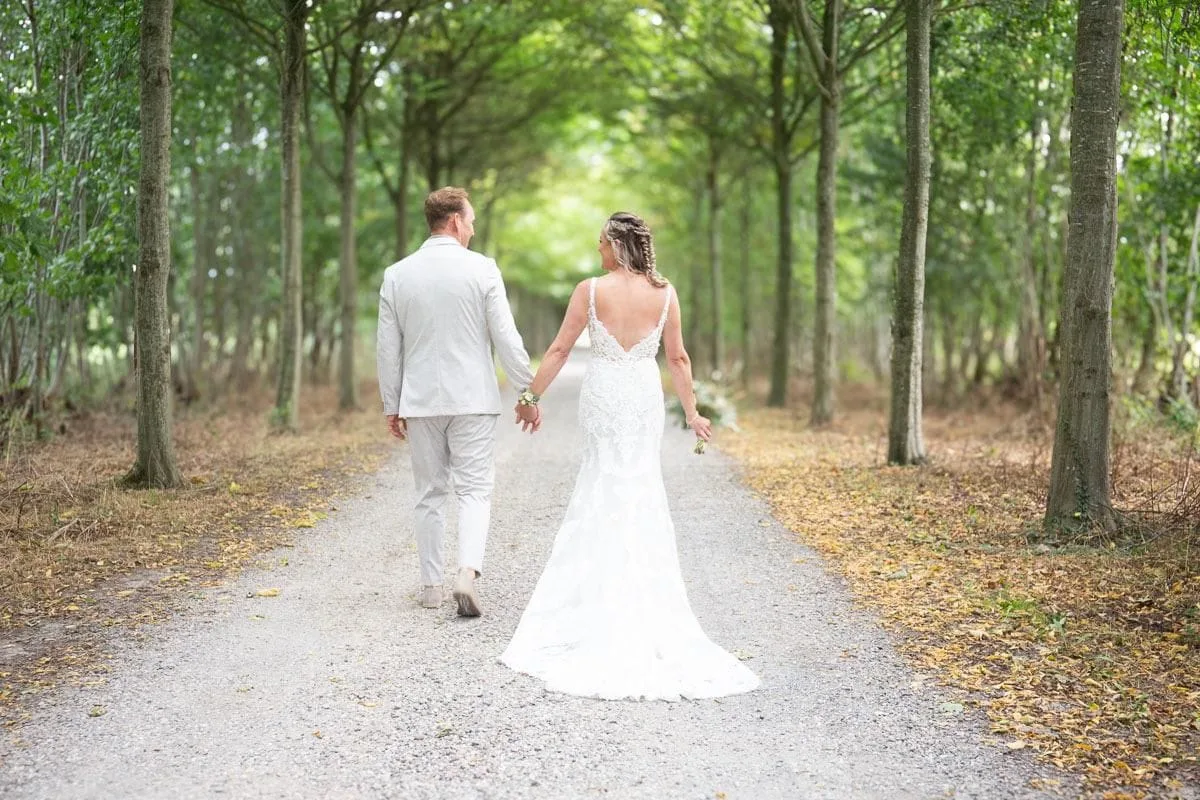 Marlisa en haar partner op hun trouwdag in een groene laan
